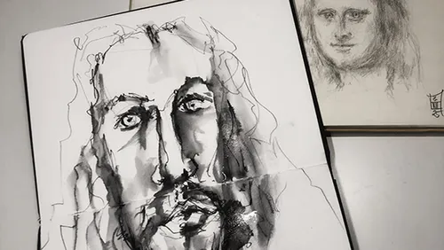 Abstract face sketches on open notebooks.