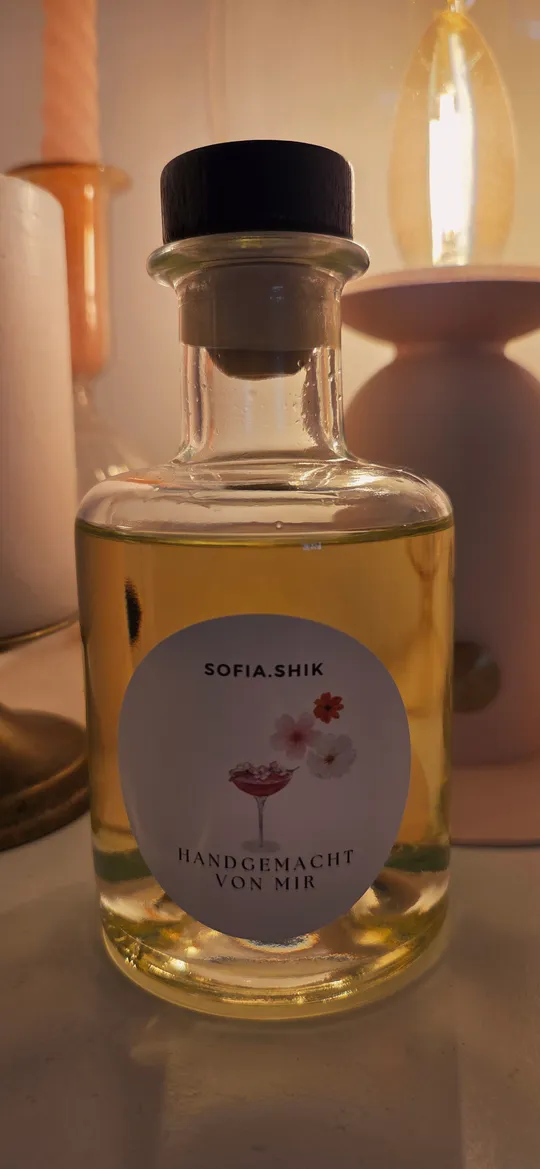 Glasflasche mit handgeschriebenem Etikett auf Tisch.