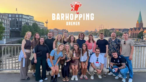 Gruppe posiert auf Brücke bei Sonnenuntergang in Bremen.