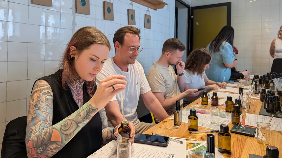 Personen stellen Düfte am Workshop-Tisch her.