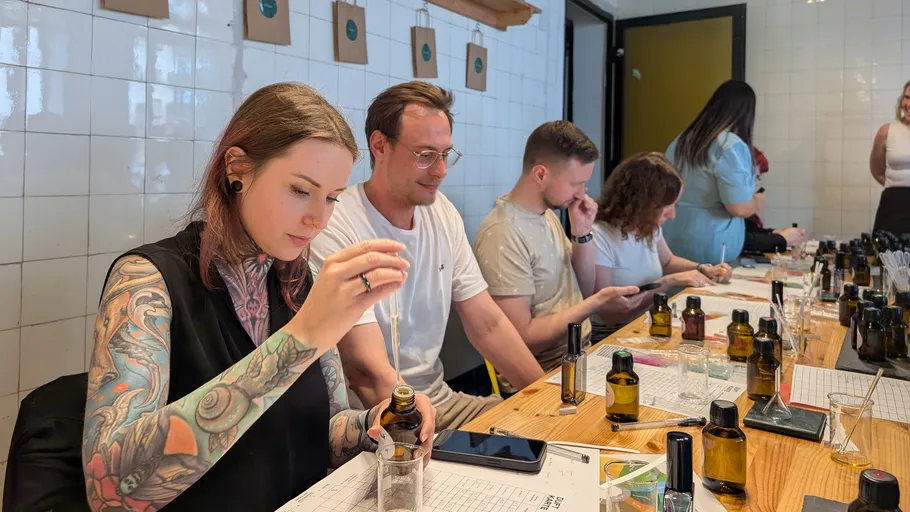 Personen mischen Düfte an einem Workshop-Tisch.