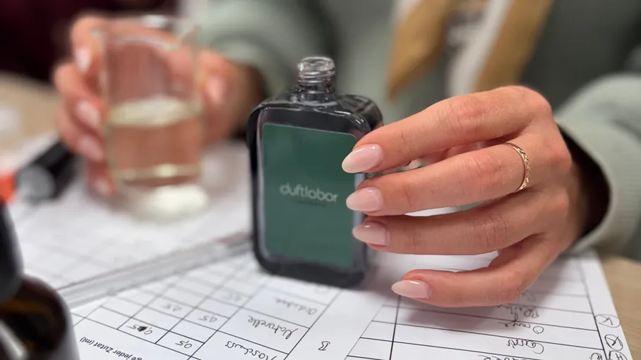 Hand hält Flasche über Dokumenten.