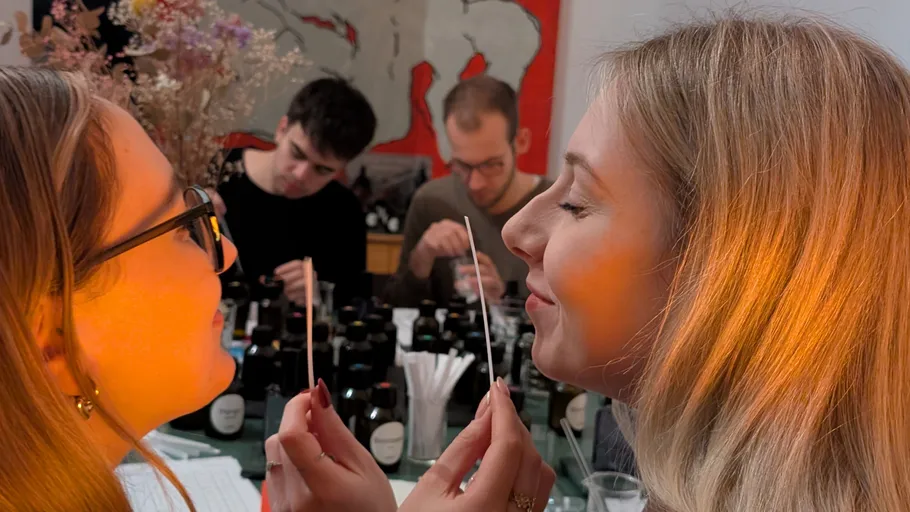 Women smelling fragrance strips in fragrance workshop.