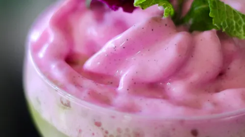 Rosa Mousse im Glas mit Minze garniert.