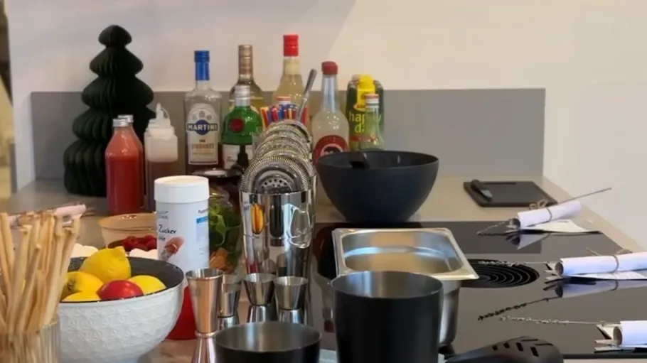 Kitchen counter with liquor bottles and utensils.