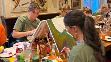 Frauen malen bei einem Kunstworkshop in einem Café.