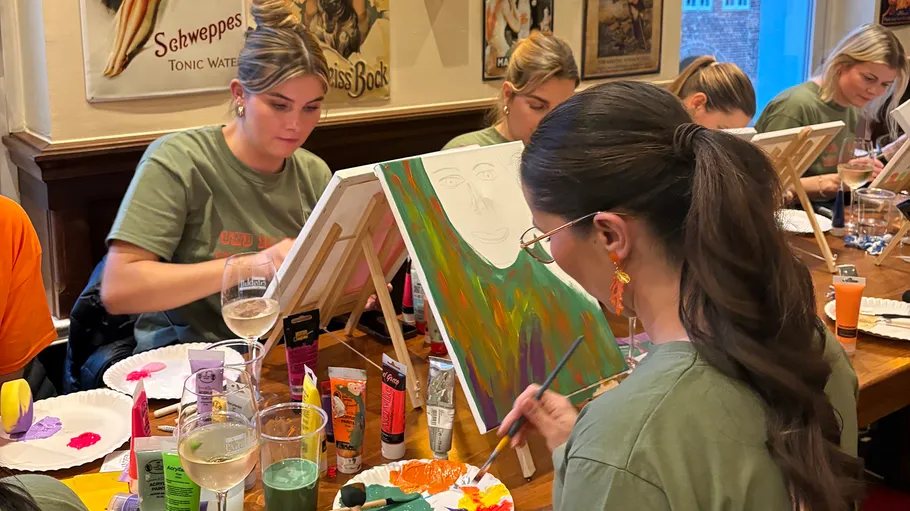 Women painting at an art workshop in a cafe.