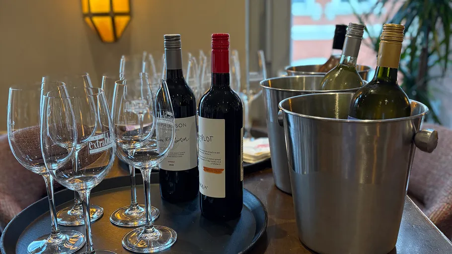 Wine bottles and glasses on table indoors.