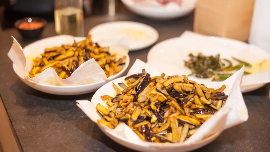 Fried eggplant strips on paper towels.