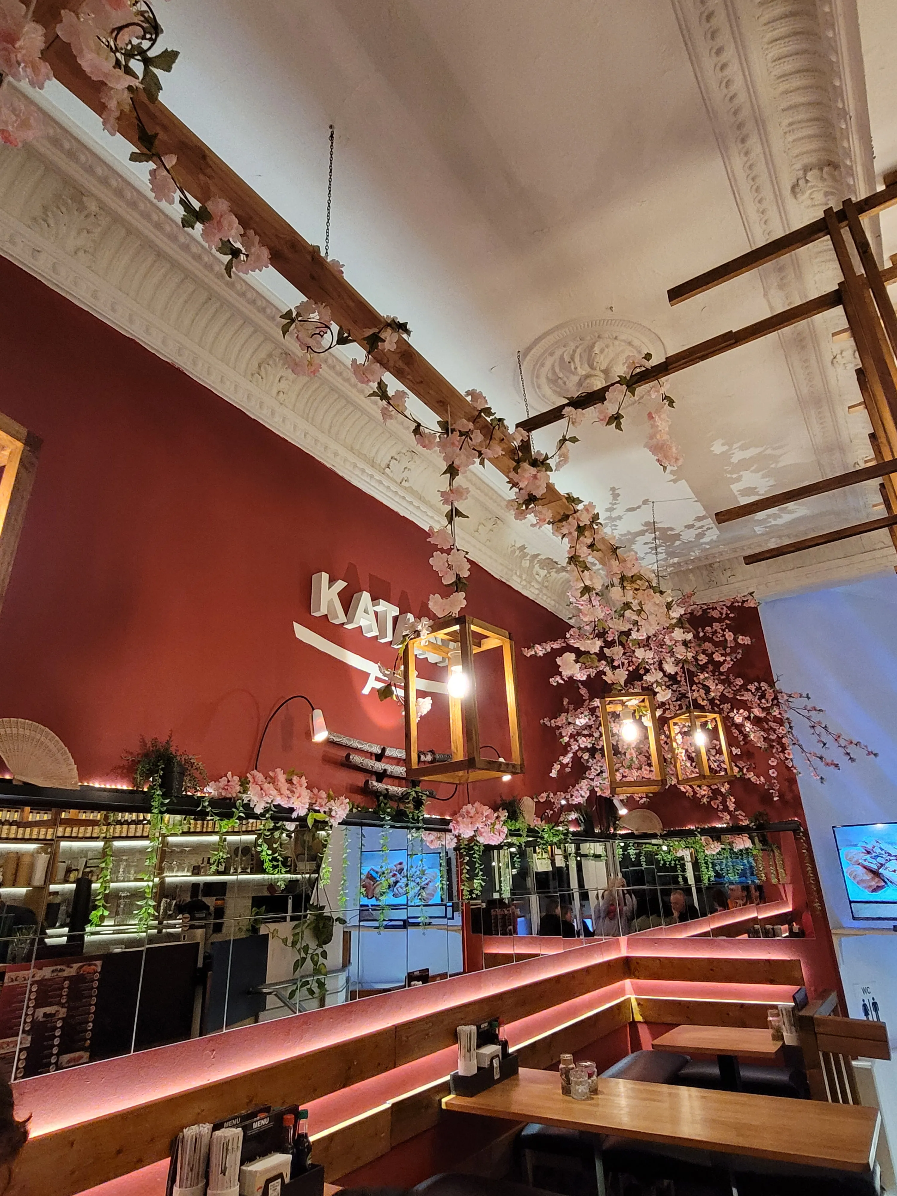 Restaurant mit Kirschblütendekoration und Tischen.