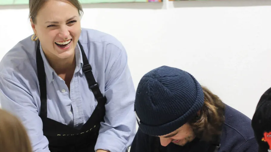 Smiling woman and man in aprons indoors.