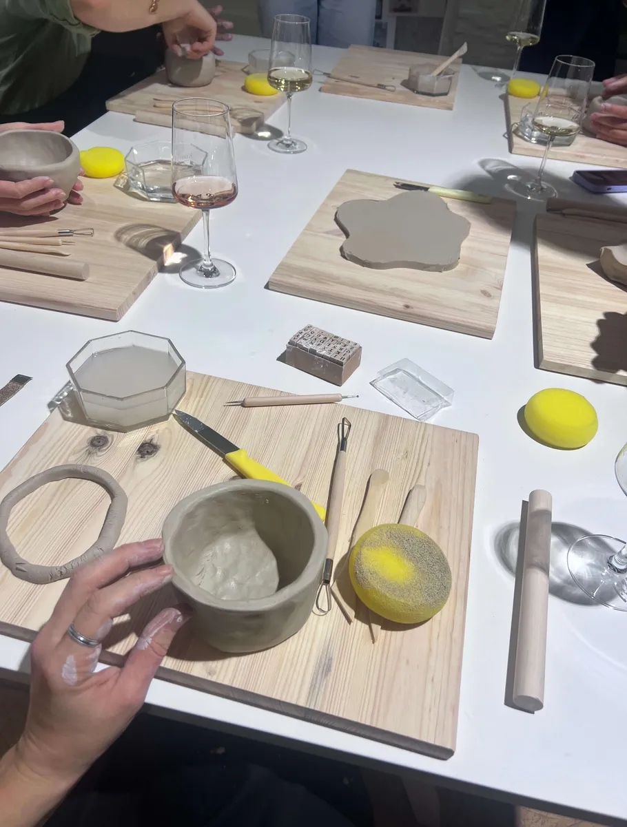 People crafting pottery at a table.