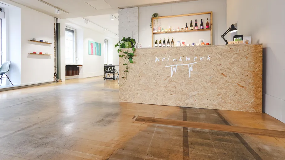 Reception desk with wine bottles in modern space.