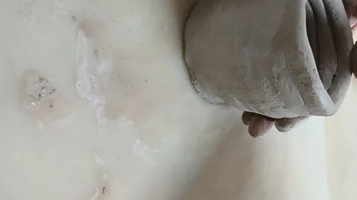 Hände formen Ton auf glatter Oberfläche.