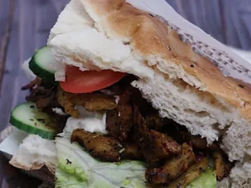 Sandwich mit gegrilltem Fleisch, Gemüse und weichem Brötchen.