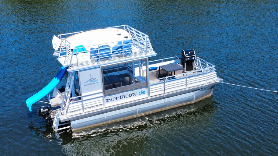 Schwimmendes Partyboot mit Rutsche auf Wasser.