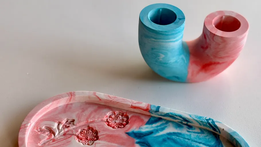 Colorful pipe candle holder and tray on table.