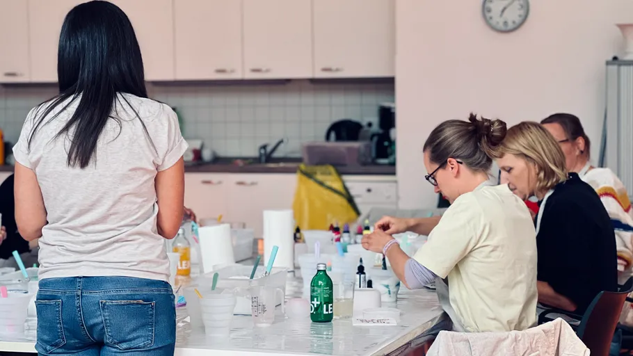 Menschen basteln an einem Tisch drinnen.