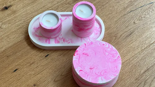 Pink marbled candles on wooden table.