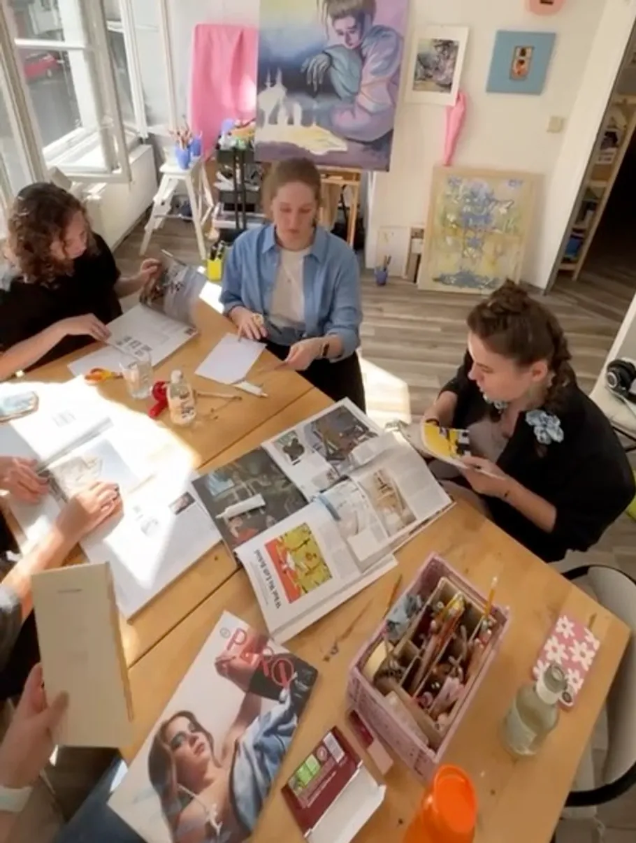 People working with magazines on a table.