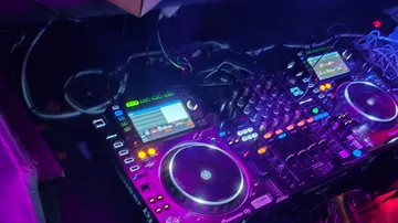 DJ equipment with glowing controls and screens.