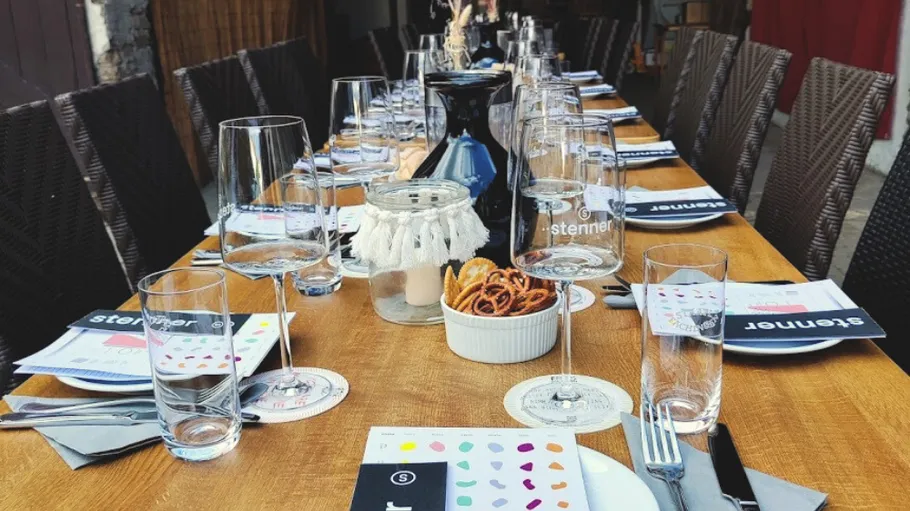 Long dining table set with glasses and menus.