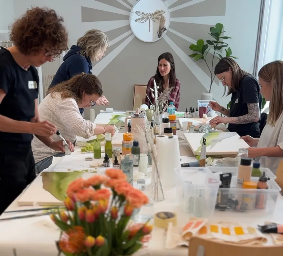 Women painting at a workshop table.