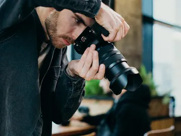 A photographer takes a photo in a coffee shop.