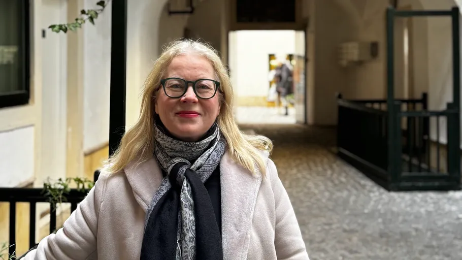 Frau lächelt in einem Kopfsteinpflaster-Gang.