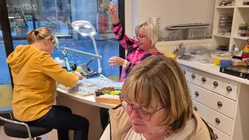 Women crafting jewelry in a workshop.
