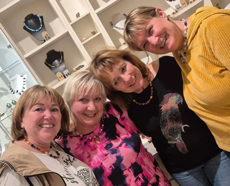 Four women smiling in a jewelry store.
