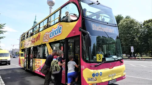 Yellow double-decker tour bus boarding passengers.