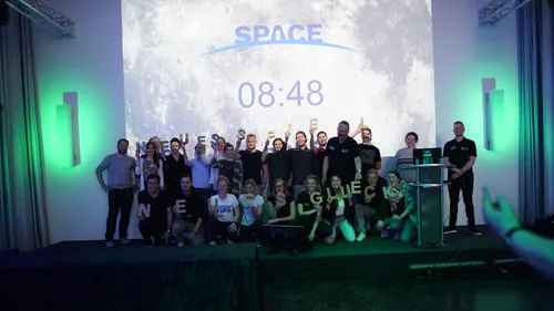 Group posing under space escape countdown timer.