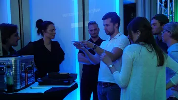 Gruppe von Menschen in Diskussion im Innenraum.