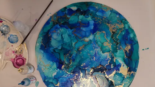 Runde Leinwand mit blauen Farben und goldenen Akzenten.