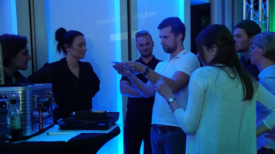 Group discussing papers in blue-lit room.