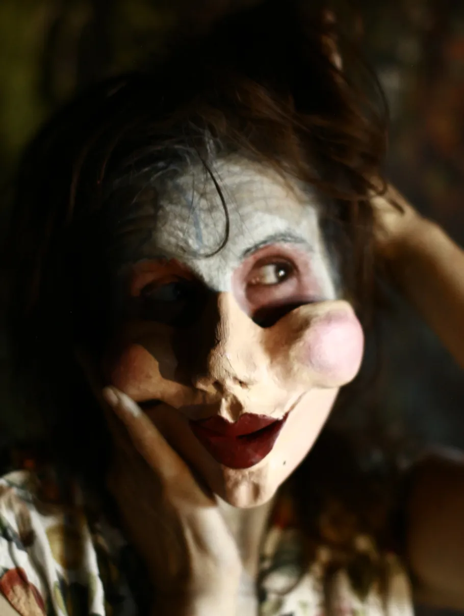 Person with mask in dimly lit room.