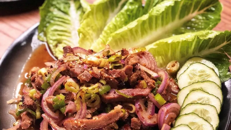 Spicy beef salad on plate with vegetables.