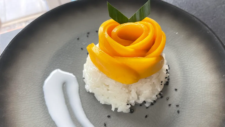 Mango rose atop sticky rice cuisine.