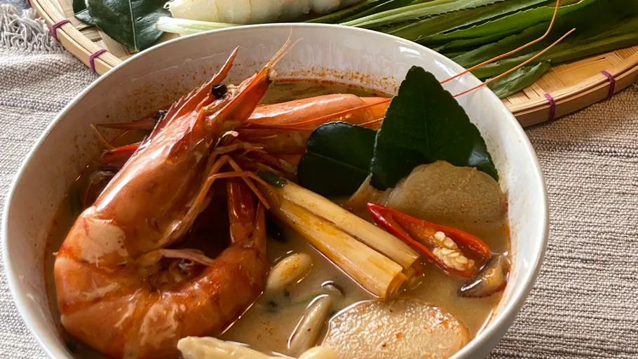 Shrimp soup with herbs and chili garnish.
