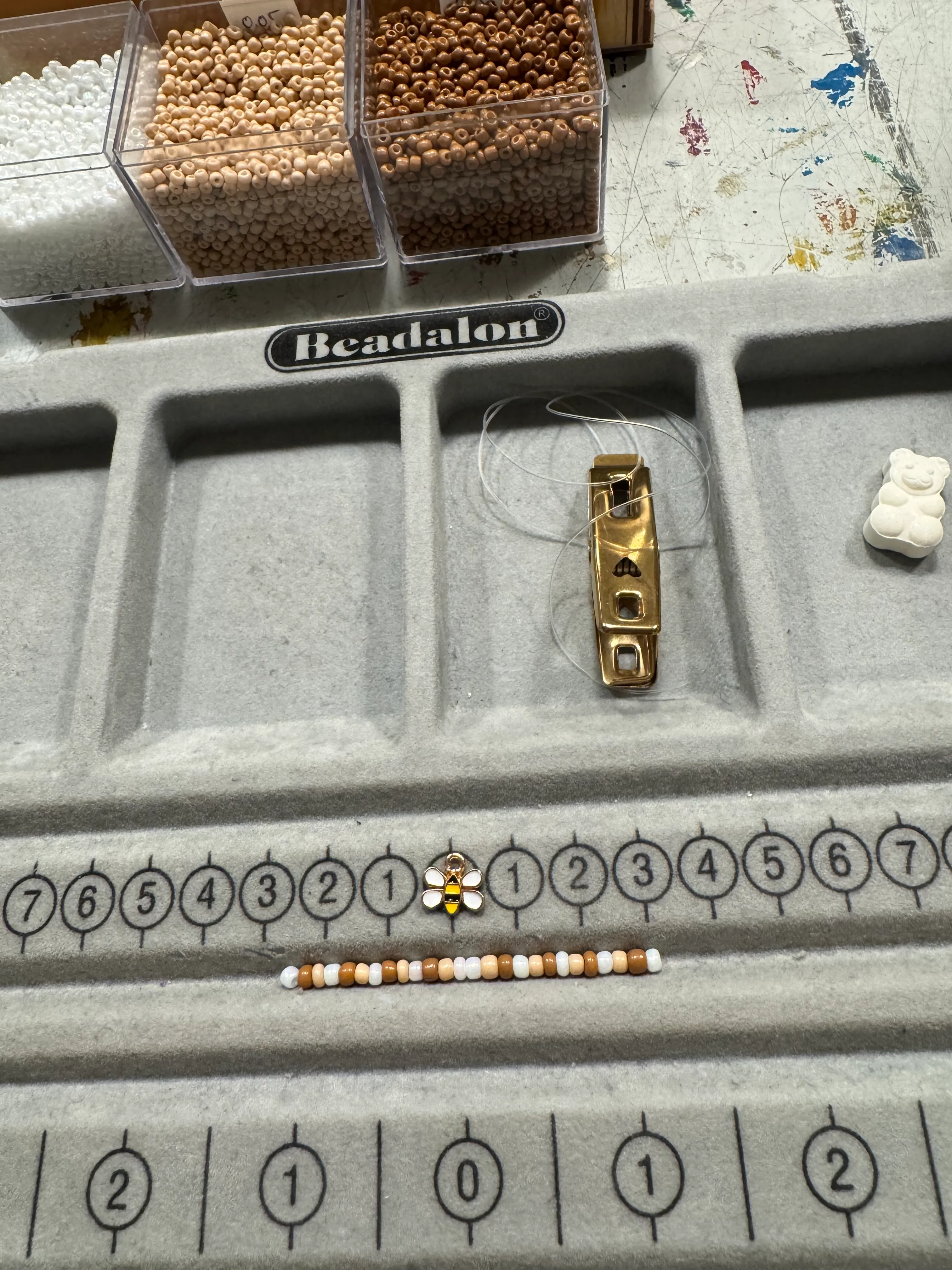 Beads and jewelry tools on a crafting mat.