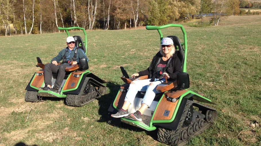 Zwei Personen fahren Geländefahrzeuge im Freien.