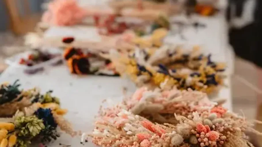 Colorful dried flower wreaths on a table.