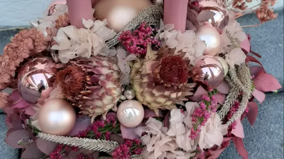 Floral arrangement with candles and ornaments.