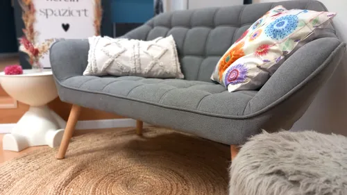 Gray sofa with pillows in cozy room.