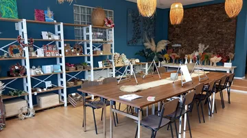 Craft workshop with tables and shelves of materials.
