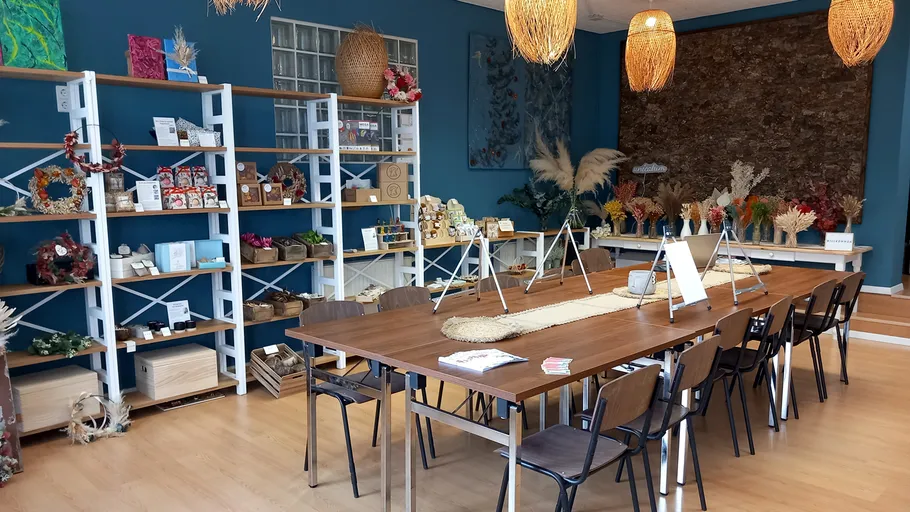 Bastelwerkstatt mit Tischen und Regalen voller Materialien.