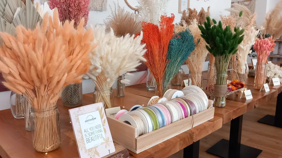 Colorful dry flowers displayed on shelves indoors.