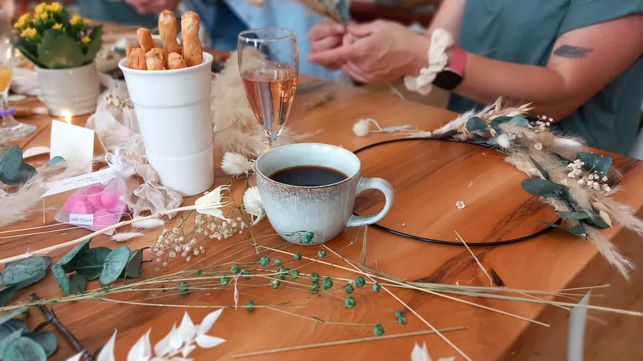 Hände basteln Kränze auf Holztisch.