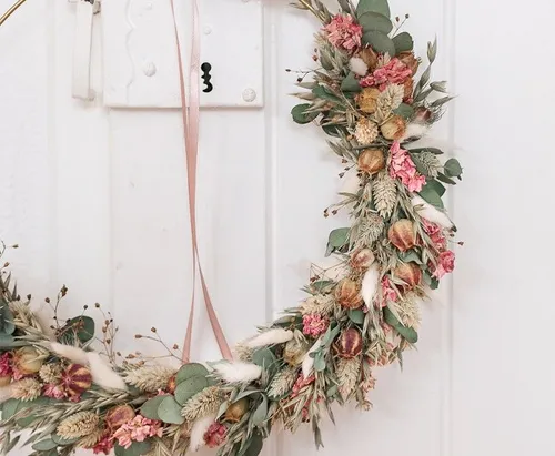 Floral wreath hanging on a white door.